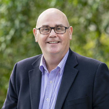 Tony Hallam looking at a camera, smiling