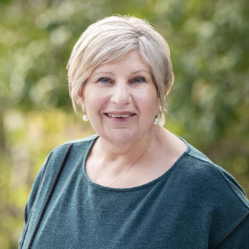 The Hon Marsha Thomson looking at a camera, smiling