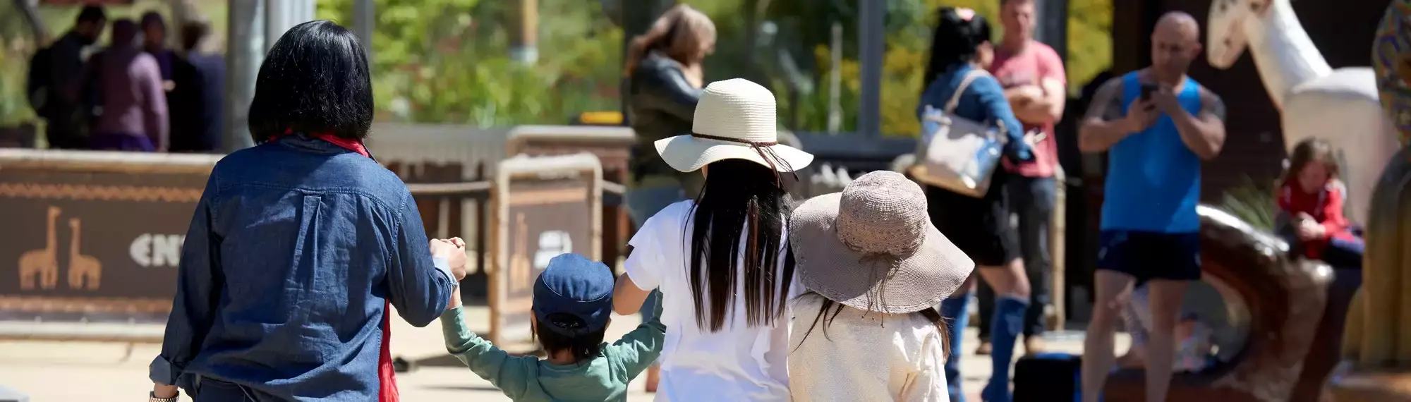 A family of your people holding hands, facing away from the camera,