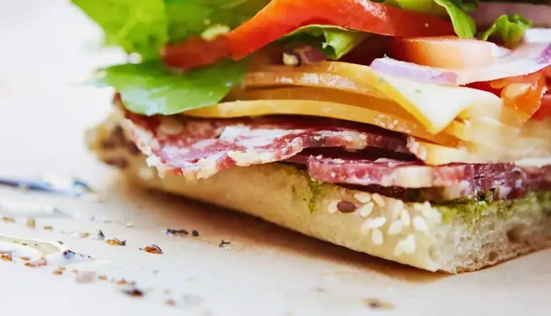 Close up photo of a focaccia cut in two showing various ingredients.